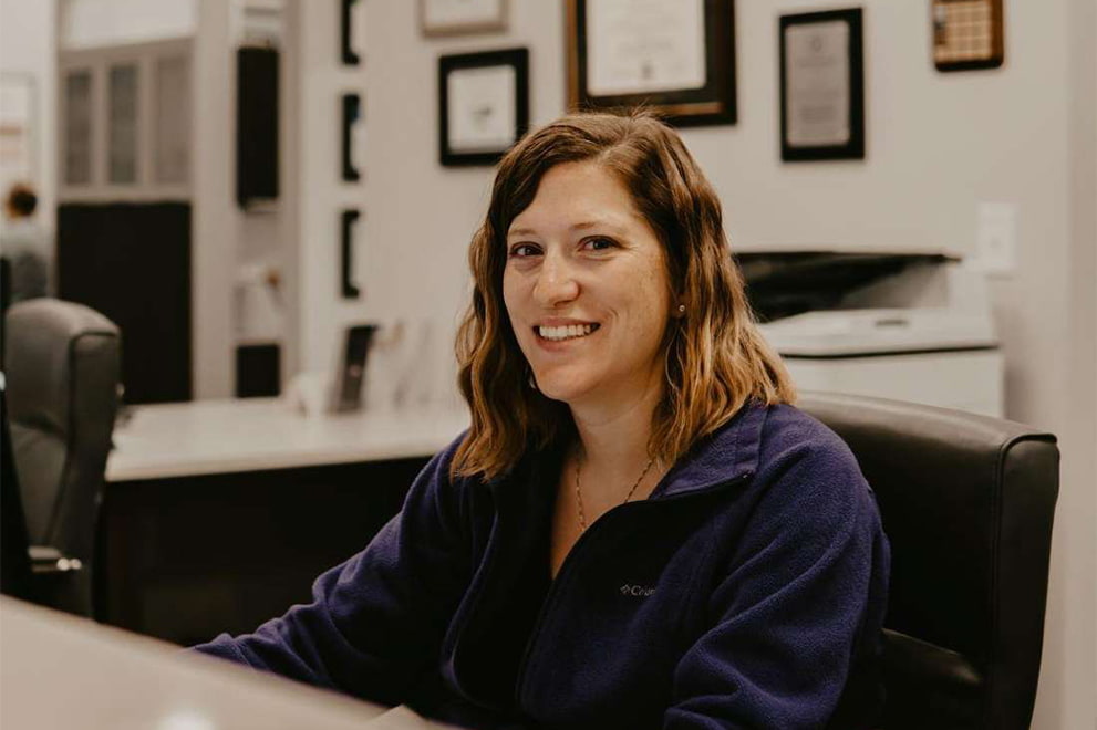 Woman sitting at desk in office environment.
