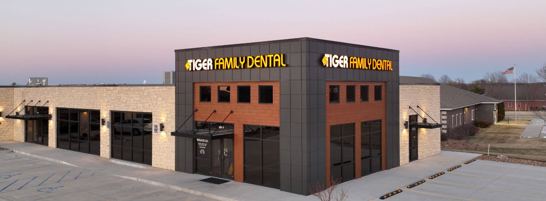 The image shows a modern building with a sign that reads  Dentist  on its facade, indicating it s a dental clinic.